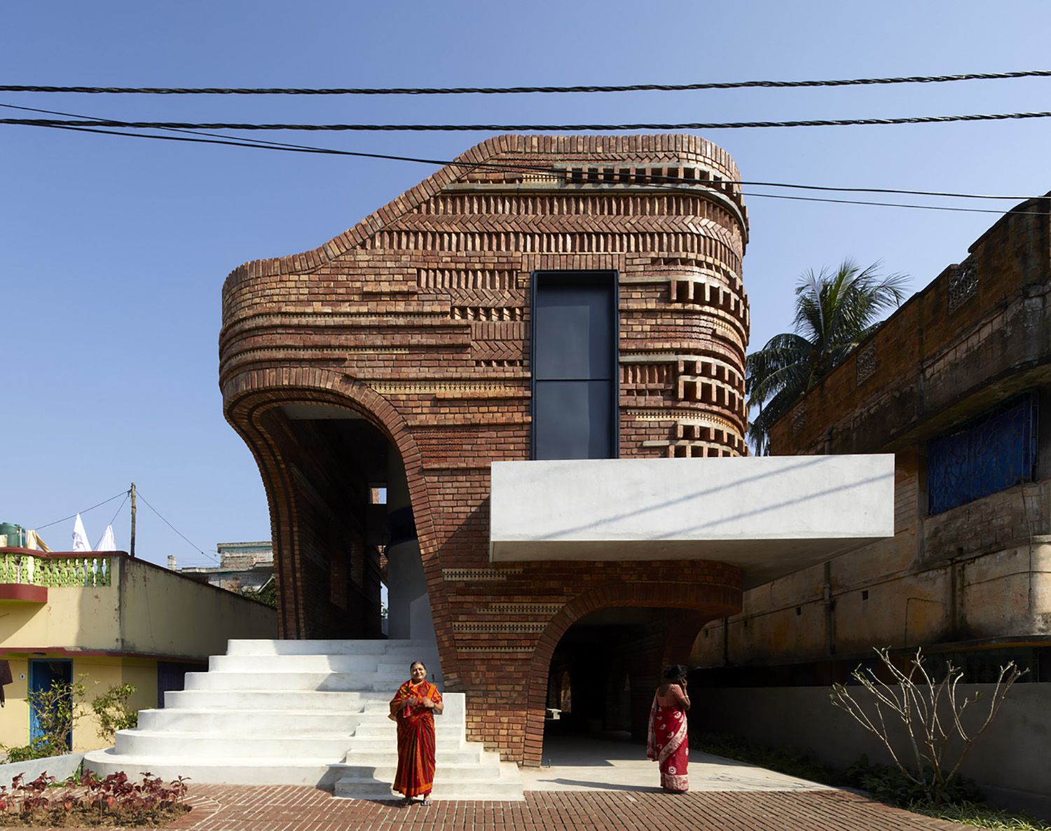 Curvilinear Community Center Integrates Salvaged Bricks and Ceramics